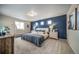 Comfortable bedroom with a large blue accent wall, carpet flooring, and natural light from multiple windows at 13586 E 103Rd Pl, Commerce City, CO 80022