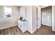 Hallway featuring hardwood floors, white storage cabinet, and access to the laundry area at 13586 E 103Rd Pl, Commerce City, CO 80022