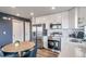 Modern kitchen features stainless steel appliances, white cabinets and an adjacent dining area at 13586 E 103Rd Pl, Commerce City, CO 80022