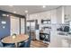 Modern kitchen features stainless steel appliances, white cabinets and an adjacent dining area at 13586 E 103Rd Pl, Commerce City, CO 80022