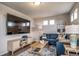 Stylish living room features a large screen TV, a blue sofa, and a decorative area rug at 13586 E 103Rd Pl, Commerce City, CO 80022