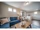Well-lit living room with a cozy seating area, a large window with scenic views, and neutral wall colors at 13586 E 103Rd Pl, Commerce City, CO 80022