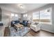 Inviting living room with a large window and comfortable blue L-shaped sofa on a decorative area rug at 13586 E 103Rd Pl, Commerce City, CO 80022