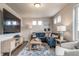 Modern living room with a blue sofa, wooden coffee table, TV, and large area rug at 13586 E 103Rd Pl, Commerce City, CO 80022
