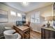 Office with wood floors, light colored walls, wooden desk, leather chair, two monitors, and blind covered windows at 13586 E 103Rd Pl, Commerce City, CO 80022