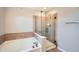 Modern bathroom featuring a soaking tub and a separate glass-enclosed shower with tile surround at 2538 Central Park Blvd, Denver, CO 80238