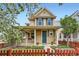 Charming two-story home with front porch and vibrant red picket fence enhancing curb appeal at 2538 Central Park Blvd, Denver, CO 80238