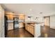 Modern kitchen features wood cabinets, black appliances, and a breakfast bar overlooking the living area at 2538 Central Park Blvd, Denver, CO 80238