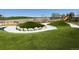 A colorful and inviting playground features soft turf, climbing structures, and a slide at 2538 Central Park Blvd, Denver, CO 80238