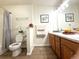 A functional bathroom features wood cabinets, double sinks, a toilet, and a shower-tub combination at 4451 S Ammons St # 108, Littleton, CO 80123