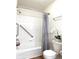 A bathroom features a tub and shower combination with white tile and wood-style flooring at 4451 S Ammons St # 108, Littleton, CO 80123