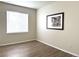 A cozy bedroom features wood-style flooring, a window for natural light, and wall decor at 4451 S Ammons St # 108, Littleton, CO 80123