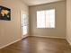 A bedroom is bright with natural light, featuring wood-style flooring, and a glass door to the outside at 4451 S Ammons St # 108, Littleton, CO 80123