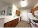 A well-lit kitchen features wood cabinets and modern appliances with white countertops, and wood-style flooring at 4451 S Ammons St # 108, Littleton, CO 80123