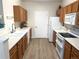 A bright kitchen features wood cabinets, modern appliances, white countertops, and wood-style flooring at 4451 S Ammons St # 108, Littleton, CO 80123