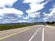 Picturesque street view of rolling hills, enhanced by a clear sky with puffy clouds for an idyllic setting at 4451 S Ammons St # 108, Littleton, CO 80123