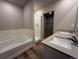 Modern bathroom with a double sink vanity, a shower, and a soaking tub at 48299 Shetland Dr, Bennett, CO 80102