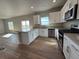 Bright kitchen features stainless appliances, white cabinetry, and counter seating at 48299 Shetland Dr, Bennett, CO 80102
