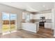 Bright kitchen featuring white cabinets, stainless steel appliances, and wood-look flooring at 48299 Shetland Dr, Bennett, CO 80102