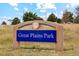 A park sign for Great Plains Park sits in front of some wild grasses and under a partly cloudy sky at 48299 Shetland Dr, Bennett, CO 80102