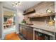 A convenient bar area with wooden shelves, sink and refrigerator for storage of your favorite beverages at 5118 Bottlebrush Run, Broomfield, CO 80023