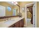 Well-lit bathroom featuring a spacious vanity with a marble countertop and a view into the adjacent shower/tub area at 5118 Bottlebrush Run, Broomfield, CO 80023