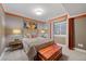 Well-lit bedroom featuring neutral colored walls, wood nightstands, and a large window with bright natural light at 5118 Bottlebrush Run, Broomfield, CO 80023