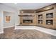 Living room featuring a modern fireplace with decorative wood accents and built-in shelving for display at 5118 Bottlebrush Run, Broomfield, CO 80023