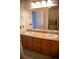 Bright bathroom with double sinks, wooden cabinetry, and large mirror at 16180 E Geddes Ln # 14, Aurora, CO 80016
