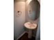 Powder room features a pedestal sink, oval mirror, and modern fixtures at 16180 E Geddes Ln # 14, Aurora, CO 80016