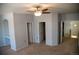 Spacious carpeted bedroom featuring a ceiling fan, built in desk, and multiple doors at 16180 E Geddes Ln # 14, Aurora, CO 80016