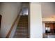 Carpeted staircase with a wooden railing leads up to a hallway and second level at 16180 E Geddes Ln # 14, Aurora, CO 80016
