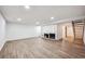 Finished basement with light wood floors, fireplace and bright white painted walls at 7755 E Quincy Ave # T2, Denver, CO 80237