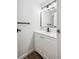 Updated half bathroom with white vanity, black faucet and modern lighting fixtures at 7755 E Quincy Ave # T2, Denver, CO 80237