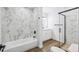 Modern bathroom with marble-look tile, glass enclosed shower, and a soaking tub with modern fixtures at 7755 E Quincy Ave # T2, Denver, CO 80237