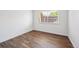 Clean and simple bedroom with wood-look floors, white walls and a sunny window for natural light at 7755 E Quincy Ave # T2, Denver, CO 80237