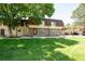 Inviting townhome exterior featuring a lush green lawn and classic brick accents at 7755 E Quincy Ave # T2, Denver, CO 80237