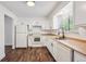 Bright kitchen with white cabinetry, modern appliances and wood-look floors. Large window provides natural light at 7755 E Quincy Ave # T2, Denver, CO 80237