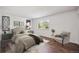 Cozy bedroom with stylish décor, wood-look floors, a comfy bed, and great lighting from a sunny window at 7755 E Quincy Ave # T2, Denver, CO 80237
