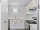 Updated kitchen with stainless steel appliances, white cabinets, new countertops, and a modern light fixture at 6455 E Bates Ave # 3-102, Denver, CO 80222