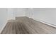 Open living room with light gray luxury vinyl flooring and two entry doors at 6455 E Bates Ave # 3-102, Denver, CO 80222