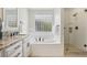 Elegant bathroom showcasing soaking tub, glass block window, and a walk-in shower with glass door at 1290 S Milwaukee St, Denver, CO 80210