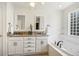 Bright bathroom features dual sinks, granite countertop, tiled floors and a relaxing soaking tub at 1290 S Milwaukee St, Denver, CO 80210