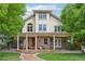Charming two-story home with brick facade, inviting front porch, manicured lawn, and mature trees at 1290 S Milwaukee St, Denver, CO 80210
