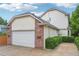 Two-story home with brick accents, an attached two-car garage, and manicured landscaping at 1290 S Milwaukee St, Denver, CO 80210
