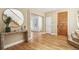 Bright foyer with hardwood floors, staircase, console table with decor, and access to other rooms at 1290 S Milwaukee St, Denver, CO 80210