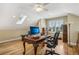 A home office boasts hardwood floors, a skylight, and a classic desk creating an inspiring workspace at 1290 S Milwaukee St, Denver, CO 80210