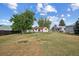 Spacious backyard with a mix of grass and dry patches, surrounded by trees and neighboring houses at 7550 Raleigh St, Westminster, CO 80030