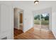Hallway leading to a full bath and an outdoor patio, featuring hardwood floors at 7550 Raleigh St, Westminster, CO 80030