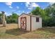 Small, well-maintained outdoor storage shed with red and white trim in grassy backyard at 7550 Raleigh St, Westminster, CO 80030